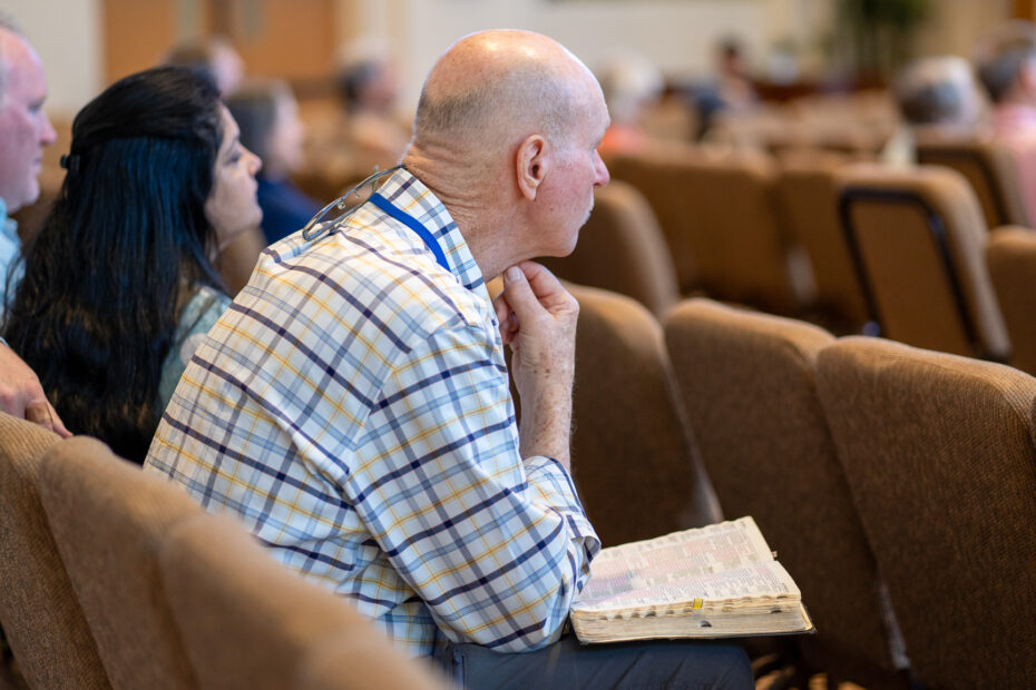 Man sitting in church with Bible open in lap